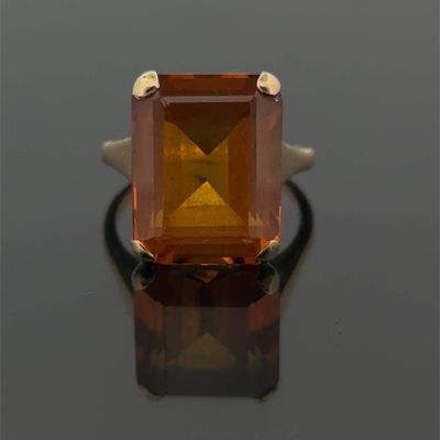 an image of a ring with an orange stone