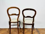 two wooden chairs sitting next to each other on top of a hard wood floor