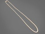 a pearl necklace with a gold clasp on a gray background