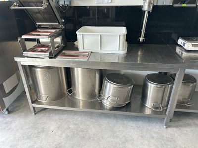 a metal table with a bunch of containers on top of it