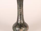 a green vase that is sitting on a white surface