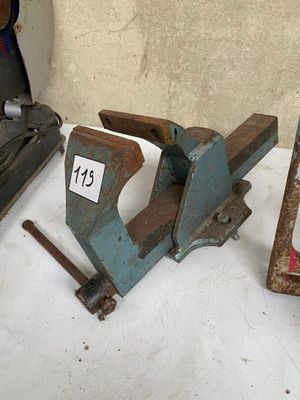 a clamp that is sitting on a table next to other tools
