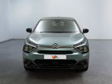 the front view of a green car parked in a white room