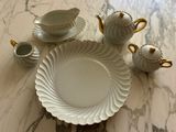 a table with a white plate and cups and saucers on it