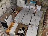 many boxes of wine sitting on the floor next to a brick wall