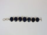 a close up of a row of blue glass beads on a silver chain