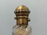 a glass bottle with a gold lid on a table