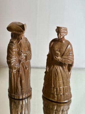 two figurines that are sitting on a glass table