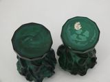 pair of green glass candlesticks on a white surface