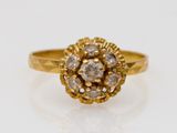 gros plan d'une bague en or avec des diamants sur une surface blanche