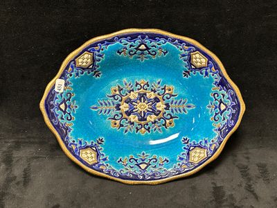 une image représentant une assiette bleue et dorée sur fond noir