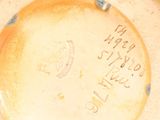 a yellow plate with writing on it sitting on a table