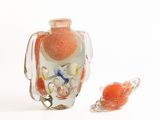 a small glass vase with a bird on it next to a smaller glass vase