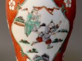 a red vase with a picture of a man and a woman on it