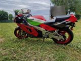 a red and green motorcycle parked in the grass