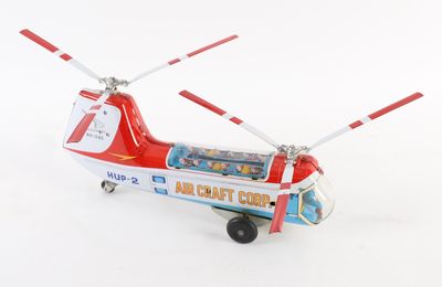un hélicoptère rouge et blanc posé sur une surface blanche