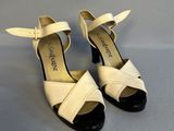 une paire de sandales blanches et noires à talon noir