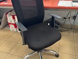 a black office chair sitting in front of a computer desk