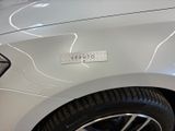 a close up of a white car with a sticker on it