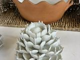 a small white flower sitting on a table next to a bowl