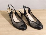a pair of black shoes sitting on top of a wooden table