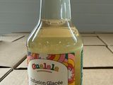 a bottle of lemonade sitting on a tile floor