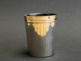 a metal cup that has a shadow of a person on it