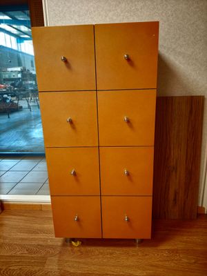 une grande commode en bois à six tiroirs placée devant une fenêtre