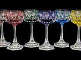 six verres à vin de couleurs différentes sont alignés