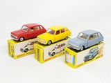 quatre petites voitures posées sur des cartons, sur une surface blanche