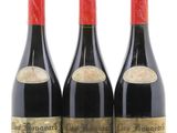 trois bouteilles de vin rouge posées l'une à côté de l'autre sur une surface blanche
