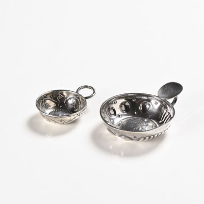 two bowls and spoons sitting on a white surface