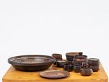 a wooden table topped with bowls and plates on it