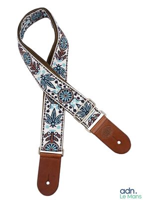une sangle de guitare à motifs floraux bleus et blancs, avec des embouts en cuir marron
