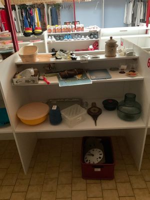 une étagère blanche sur laquelle sont posés de nombreux objets, dans une pièce