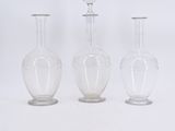 three clear glass vases sitting next to each other on a white surface