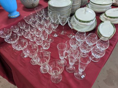 de nombreux verres et assiettes sur une table recouverte d'une nappe rouge
