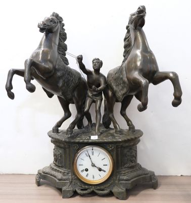 a statue of three horses and a clock on a table