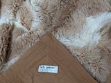 a blanket with a label on it sitting on a bed