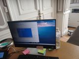 un écran d'ordinateur posé sur un bureau avec un clavier et une souris