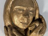 sculpture représentant une femme portant ses mains à son visage