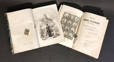 trois livres sont ouverts sur une table, sur fond noir