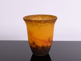 un vase marron et orange posé sur une table noire