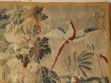 a tapestry hanging on the wall with a bird on it