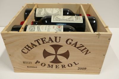 des bouteilles de vin dans une caisse en bois posée sur une table blanche