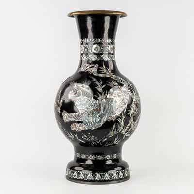 a black vase with a design on it on a white background