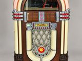 an old juke box sitting on top of a white surface