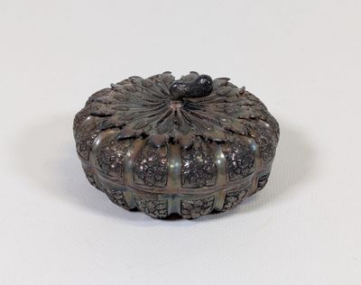 une petite boîte en métal ornée d'un motif floral