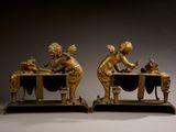 pair of antique bronze figurines of a boy and a girl at a table