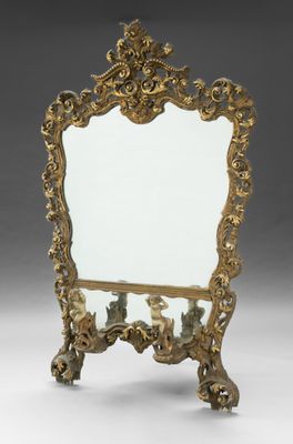 an ornately decorated mirror stands on a stand with a mirror in the middle of it